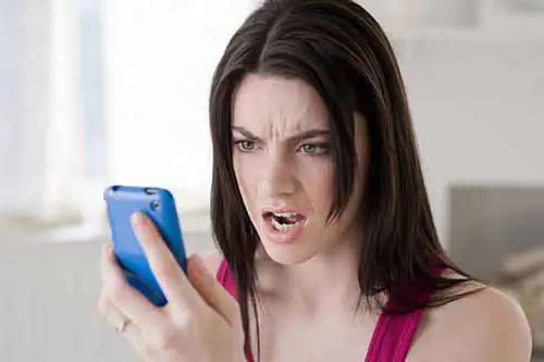 mujer enojada mirando celular